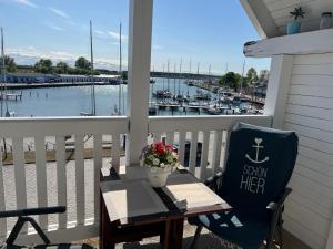a table on a porch with a view of a marina at Hafenidyll mit Wasserblick in Karlshagen +23 photos