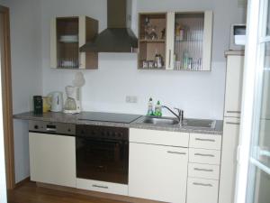 a kitchen with a sink and a stove at Hafenidyll mit Wasserblick in Karlshagen