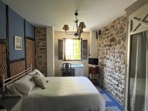 a bedroom with a bed and a stone wall at Posadaochohermanas in Las Fraguas