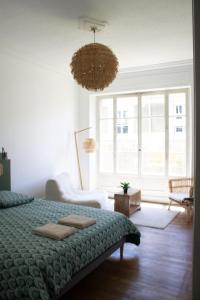 a bedroom with a bed and a chandelier at Avocado - Garage inclus - T3 - 96m2 - lumineux - Centre ville tout à pied in Grenoble