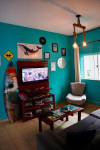 a living room with a television and a table at La Casa Hostel in Arraial do Cabo