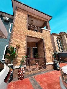 a brick house with a balcony with plants in it at The Movia Residences 1 in Enugu +2 photos