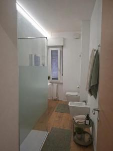 a bathroom with a toilet and a glass shower door at Mary's Sweet Home in Cagliari