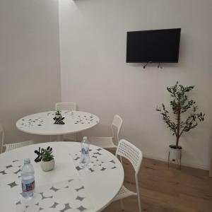 a living room with two tables and a flat screen tv at Mary's Sweet Home in Cagliari