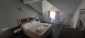 a bedroom with a bed with two towels on it at AQUA MARMARA LİFE Hotel in Marmaraereglisi