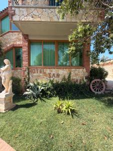 a stone house with a statue in front of it at Hotel "SAN SAENA " in Vlorë