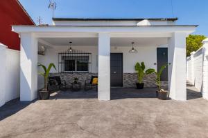 a white garage with potted plants on a patio at Casa Los Sánchez in Alhaurín de la Torre