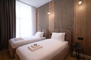 two beds in a hotel room next to a window at Waves Hotel NEW IN 2026 in Sarajevo