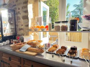 a counter with several plates of bread and pastries at Logis Hôtel La Demeure du Perron in Quettehou