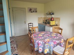a kitchen with a table and chairs and a microwave at La Vallée des Trois Monts in Saint-Sylvestre-Cappel +18 photos