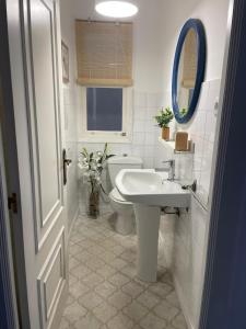 ein Badezimmer mit Waschbecken, Toilette und Spiegel in der Unterkunft Amancay in Cedeira + 9 Fotos