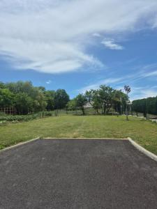 a parking lot with a field of grass and trees at Douce Escale in Vichel