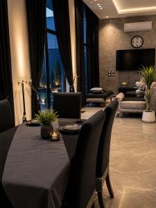 a dining room with a table and chairs and a living room at Ohio villa in Sowayma