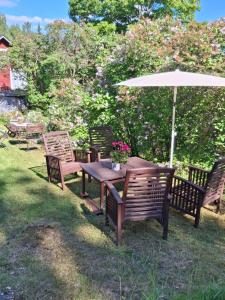 a wooden table and chairs with an umbrella at Lossiranta Tavis in Savonlinna