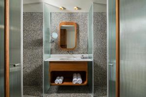 a bathroom with a sink and a mirror at Hotel 1935- By Adam Hotels in Tel Aviv +47 photos