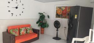 a room with a refrigerator and a chair and a clock at Casa SAYBER DON DIEGO in Don Diego