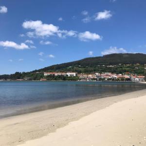 Blick auf einen Strand mit einer Stadt im Hintergrund in der Unterkunft Amancay in Cedeira