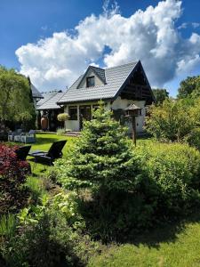 a house with a christmas tree in the yard at Villa NOVA Dębki in Dębki