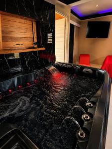 a black counter top in a kitchen with red chairs at Love room Coconut Secret in Le Gosier