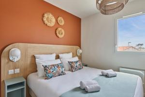 two beds in a small room with orange walls at Résidence Odalys Bleu Canopée in Mimizan