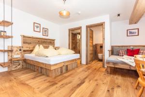 a bedroom with a bed and a wooden floor at Pension Seighof - Geschichte zum Anfassen seit 1366 - inkl Bergbahnen im Sommer - regionales Frühstück - Bergpanorama - Joker Card in Saalbach-Hinterglemm +208 photos