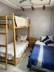 a bedroom with two bunk beds and a bed at Abrid Surf in Tamraght Ouzdar