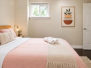a bedroom with a large bed with towels on it at Chic & Spacious 2BR Home Near Yonge St in Newmarket