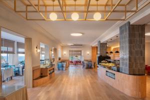 a kitchen and living room with wood floors and a ceiling at Hotel Montjoi by Brava Hoteles in Sant Feliu de Guíxols