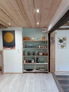 a kitchen with a shelf with dishes on it at Chez JF et ISA in Bussang +39 photos