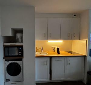 a kitchen with a sink and a microwave at Appartements Duplex de Charme à Bénodet Vue Mer in Bénodet