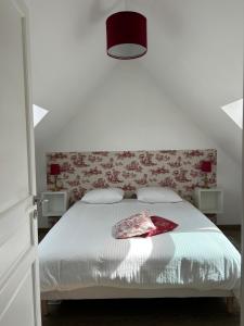 a bedroom with a white bed with a red headboard at La Bernache Solognote in Viglain