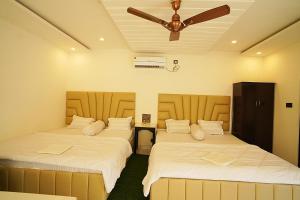 two beds in a room with a ceiling fan at Lake View Village Resort in Tajpur +74 photos