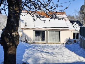 a house in the snow with a tree at La Petite Maison dans la Prairie in Cholet