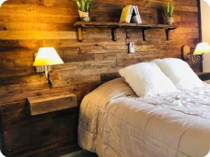 a bedroom with a wooden wall with a bed at El Madejo - del Valle de Uco in Tunuyán +83 photos