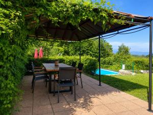 a patio with a table and chairs under a pergola at Villa Felix with spectacular pool in green oasis in Opatija