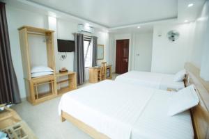 a hotel room with two beds and a television at Tân Trang in Ha Long +13 photos