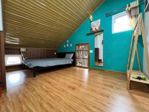 a room with blue walls and a wooden floor at TeeDalat Home in Khu Chi Lăng