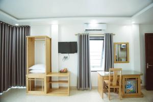 a bedroom with a bed and a desk and a table at Tân Trang in Ha Long