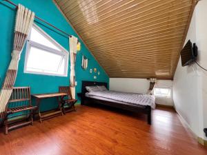 a room with a bed and a table and a window at TeeDalat Home in Khu Chi Lăng