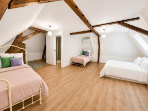two beds in a attic room with wooden floors at Maison hypocentre de Bethune in Béthune