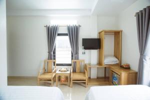 a bedroom with a bed and a table and a window at Tân Trang in Ha Long