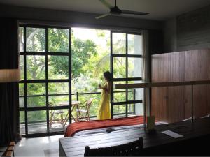 a woman in a yellow dress looking out of a window at Bisma Eight - CHSE Certified in Ubud