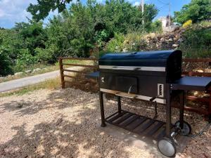 a grill sitting next to a fence on the side of a road at House Belej - Lola in Belej