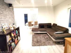 a living room with a brown couch and a book shelf at La Petite Maison dans la Prairie in Cholet