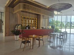 a restaurant with tables and chairs and a bar at Arena Lucky Condotel in Cam Ranh International Airport