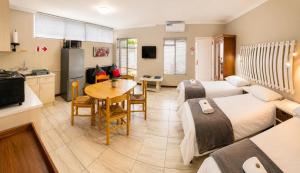 a bedroom with a bed and a kitchen with a table at Ladera - Vista Self-catering Guesthouse in Paarl