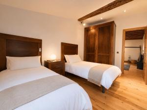 two beds in a room with wooden floors at El Palacito de Villoslada in Villoslada de Cameros