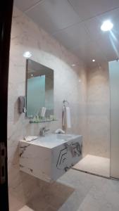 a white bathroom with a sink and a mirror at Daraysh Hotel  +142 photos