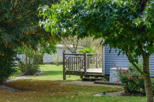 a wooden bench sitting in a yard next to a house at Les Cottages du Limonay in Saint-Méloir-des-Ondes