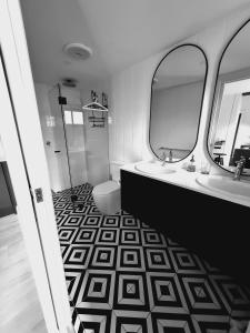 a bathroom with two sinks and a mirror at 1860 Heritage Beachside Studio in Somerton Park +6 photos